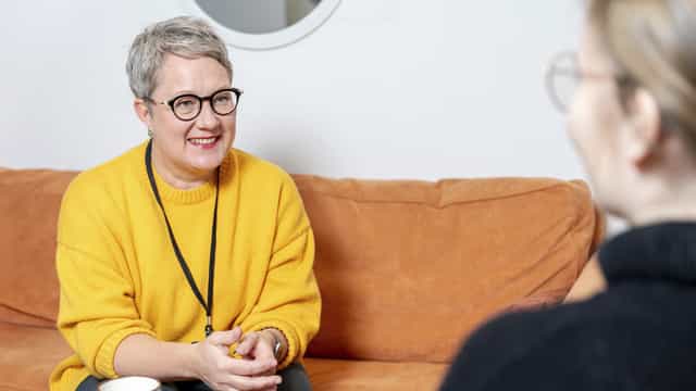 Työhönvalmentaja ja asiakas istuvat sohvalla. 
