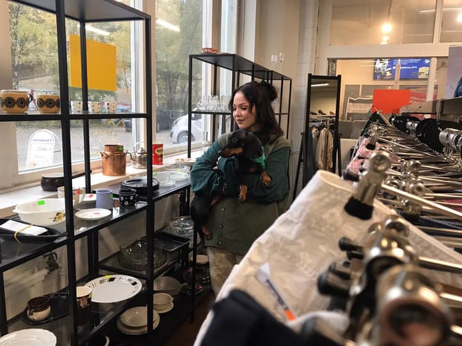 Dunja mäyräkoira sylissään Goodwillin myymälässä.
