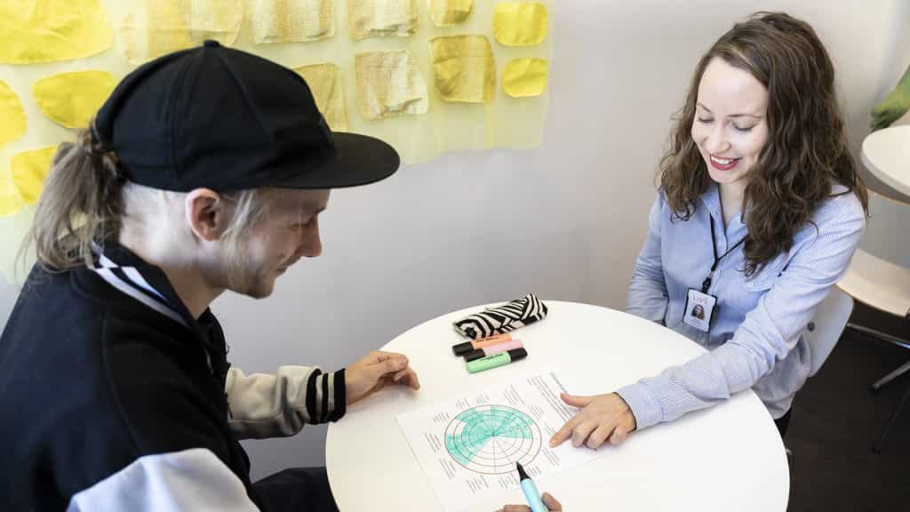 Asiakas ja psykologi pöydän ääressä tekemässä tehtävää. 