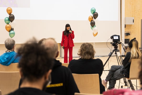 Kuvassa Mira Luoti punaisessa housupuvussa.
