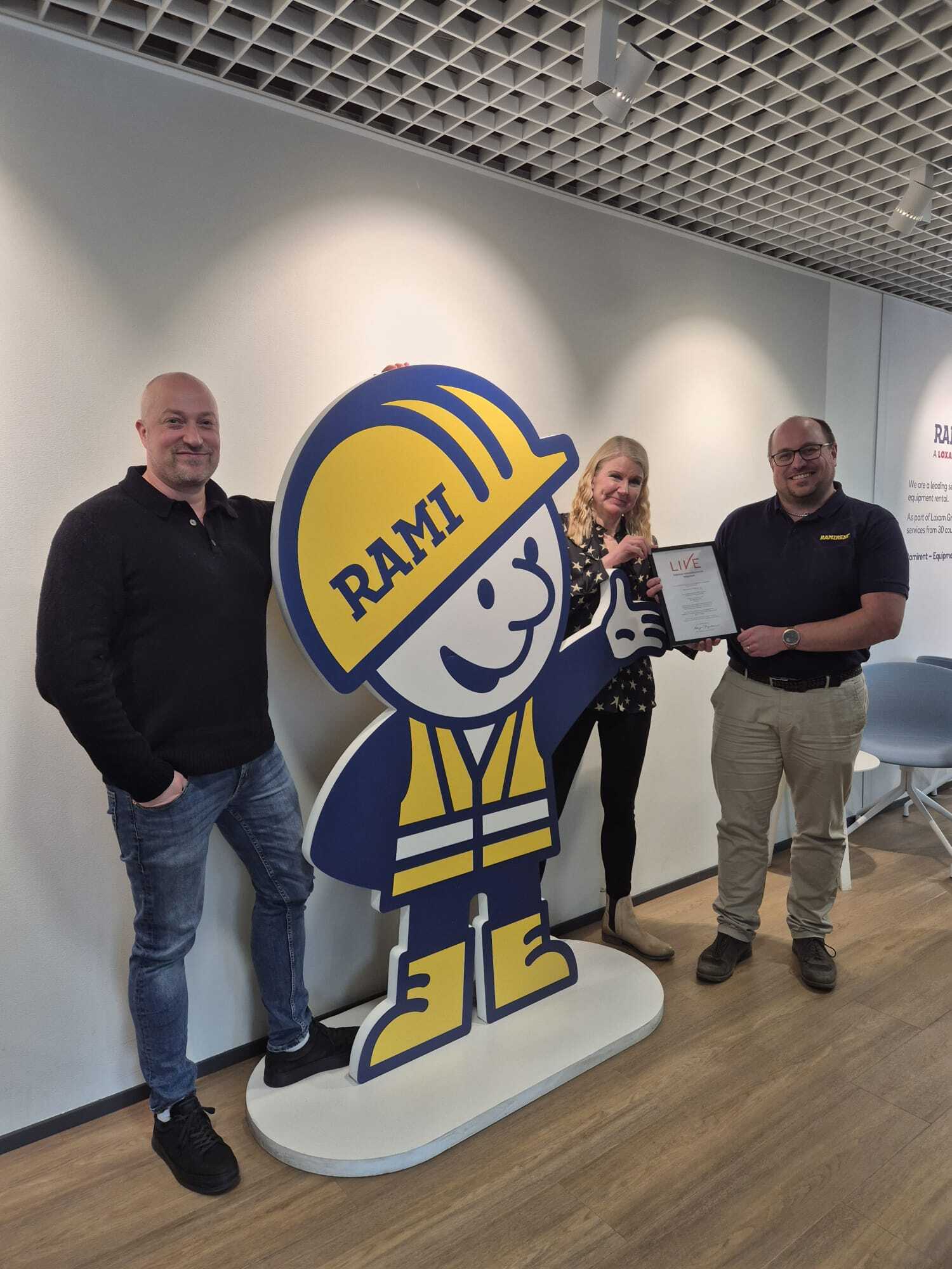 Ramirent Anne ja Henrik sekä Liven Harri poseraa Remirentin maskotin kanssa