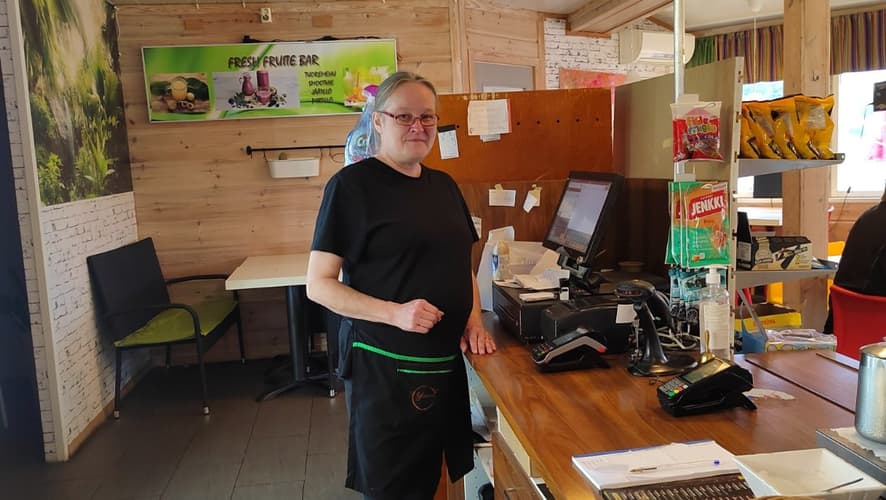 Teija Sainio seisoo grillillä tiskin takana.